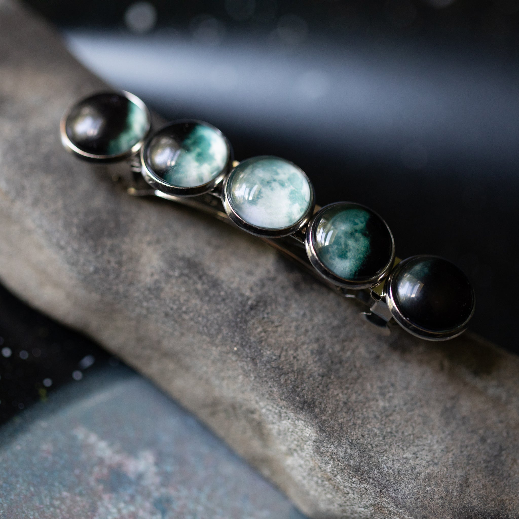 Bracelet with green and black gemstones on a stone surface